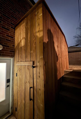 Exterior wooden home renovation in Toronto with custom vertical wood siding, modern door and staircase, part of a residential improvement project by a renovation contractor in the GTA.